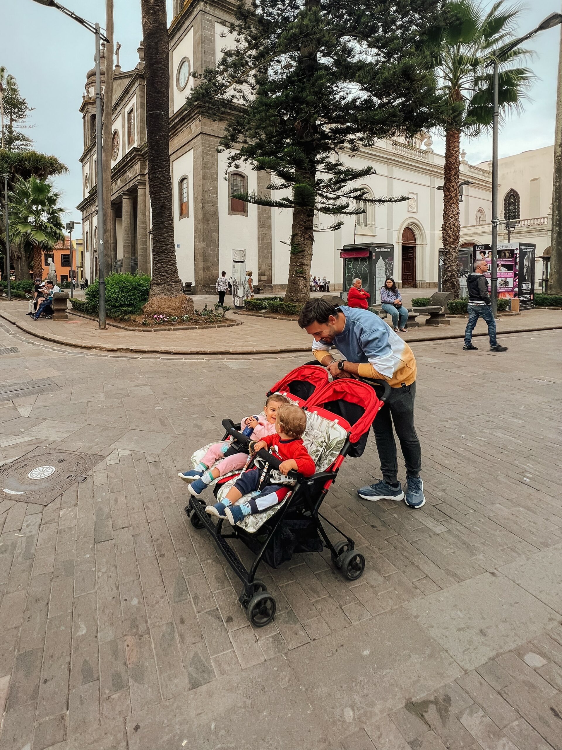 padres con bebés en carrito chicco gemelar